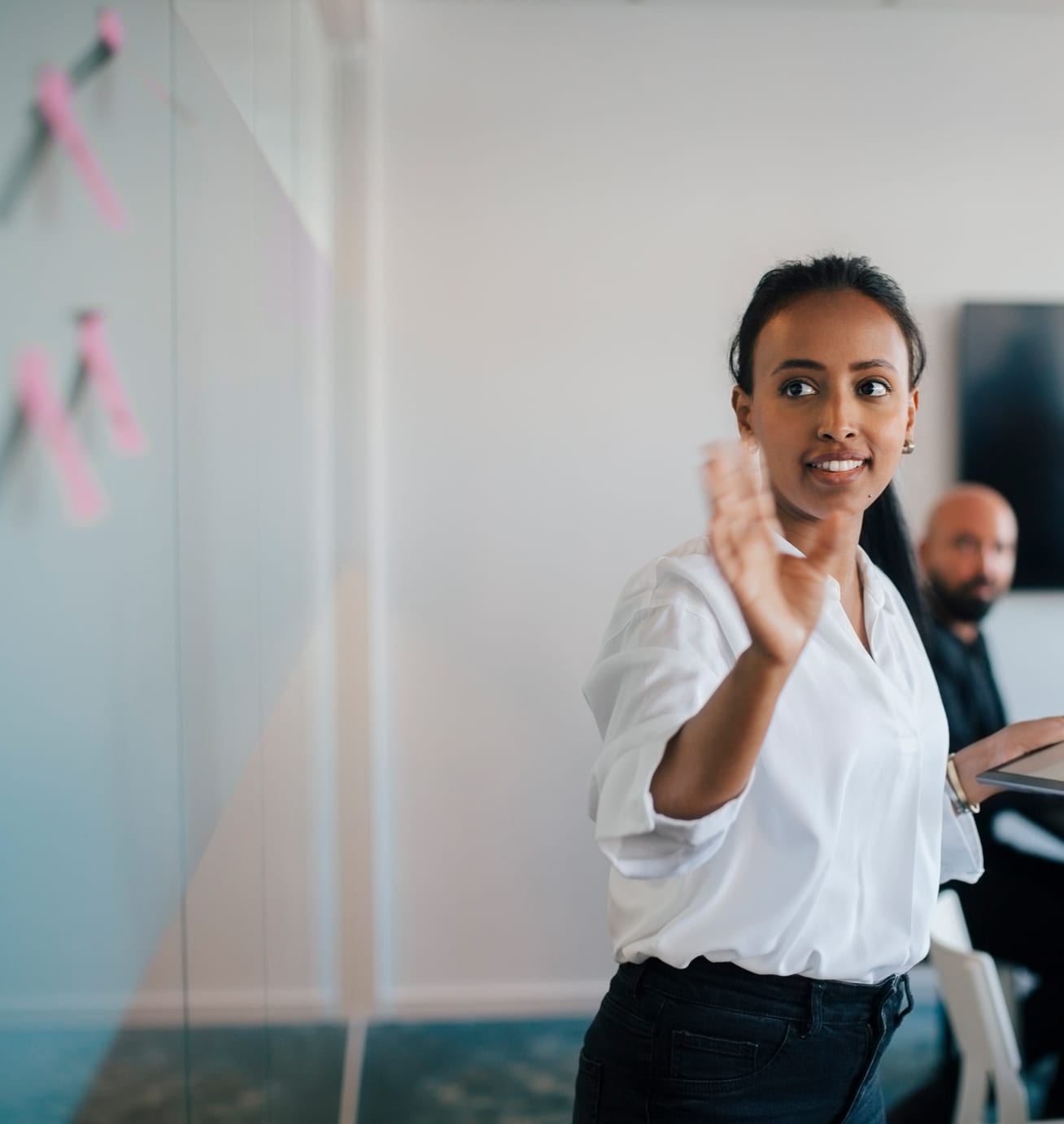Woman standing in front of and pointing to a whiteboard
