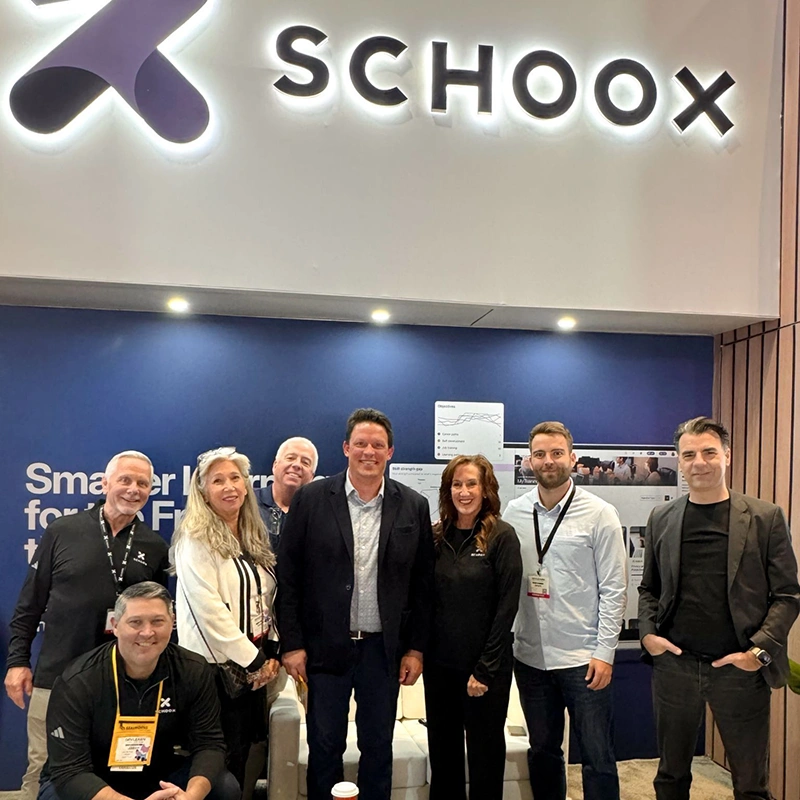 Schoox team posing together at the DevLearn conference booth