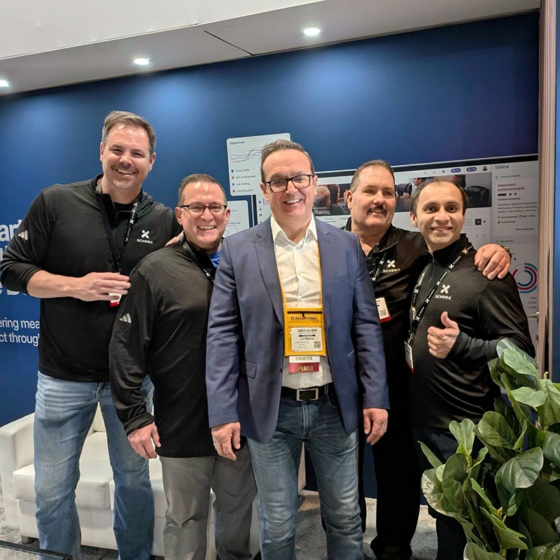 Schoox team members posing together at the DevLearn conference booth