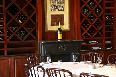 Elegant dining room with a wine bottle displayed above a fireplace and wooden wine racks