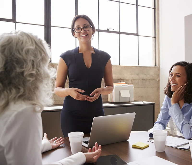 Business professional presenting to colleagues during a team meeting