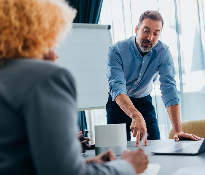 Business professional leading a discussion with colleagues during a meeting