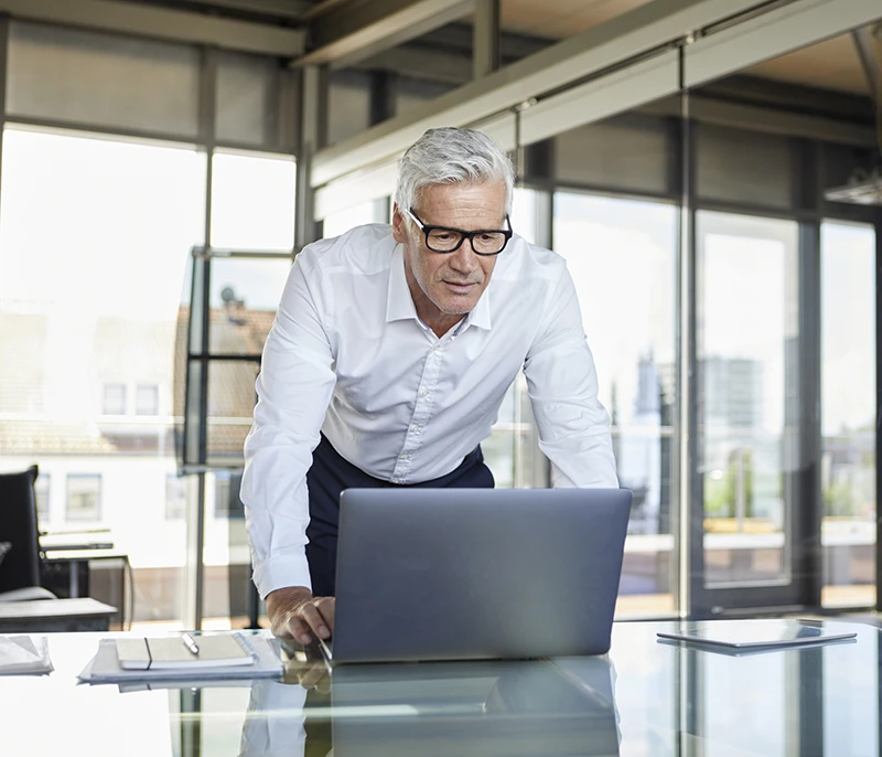 Business professional reviewing information on a laptop in a modern office