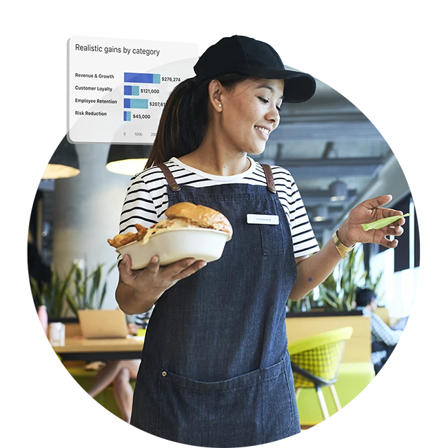 Restaurant worker holding a burger and checking a device with business performance metrics displayed