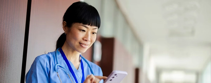 Healthcare worker using a smartphone in a clinical setting