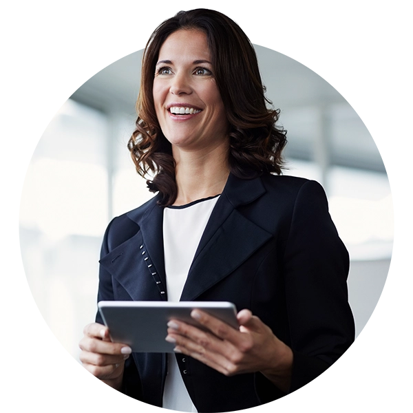 Professional woman in business attire holding a tablet and looking engaged in a workplace setting