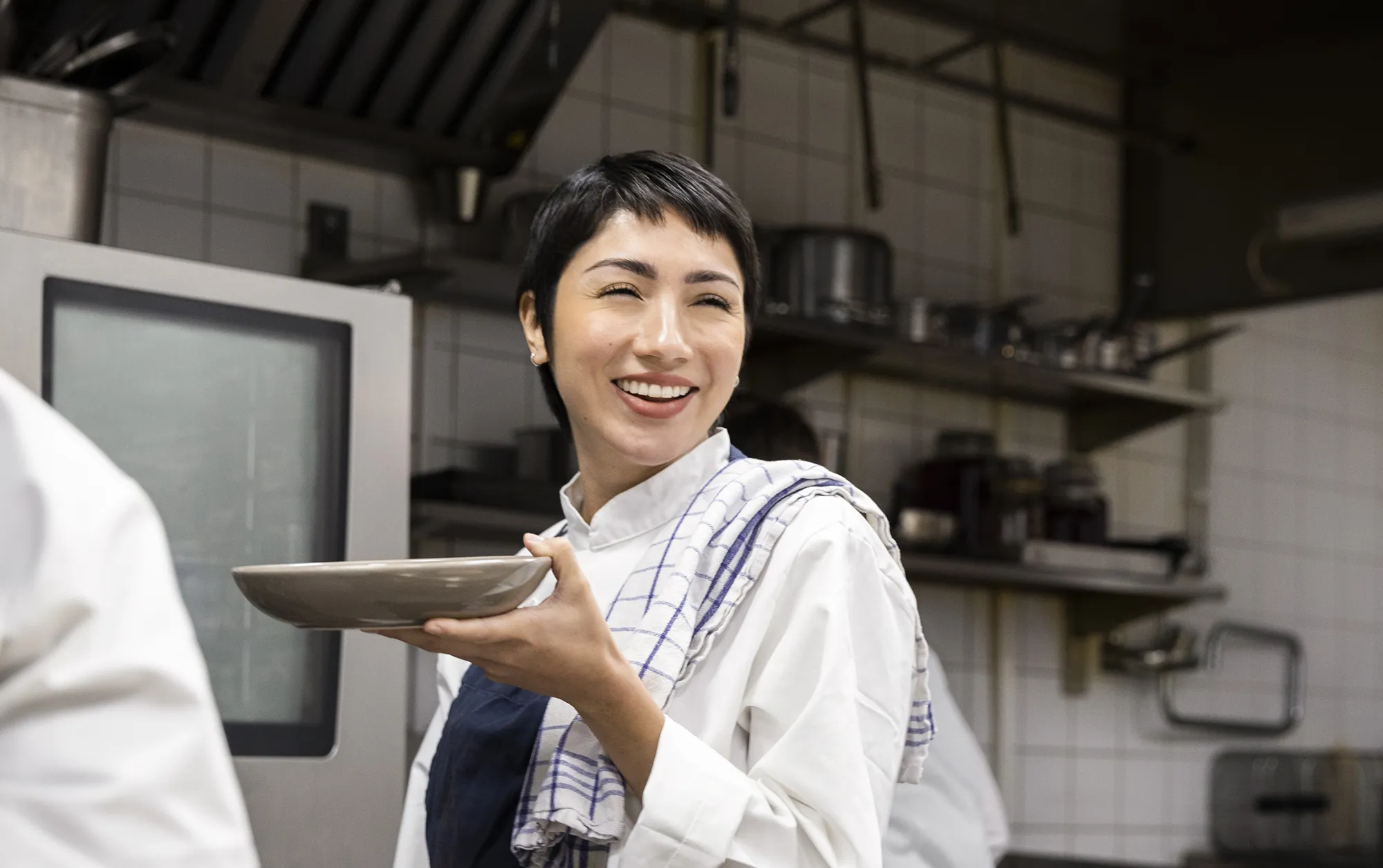 Restaurant employee holding a plate in a commercial kitchen
