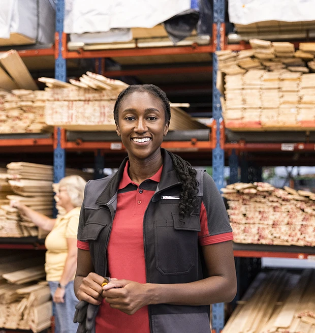 Warehouse employee standing in front of lumber storage racks