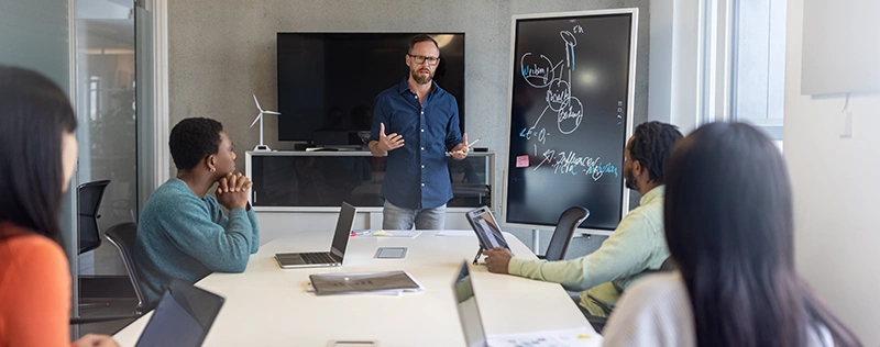 Business professional presenting to a team during a training session in a conference room