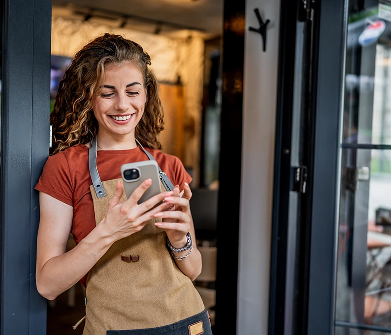 Frontline restaurant employee using a smartphone at work